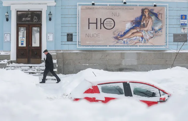 A mens walks on a snow covered street in Kiev, Ukraine, 06 February 2017. Snowfalls, wind and temperatures of down to minus 20 degrees Celsius are forecast by weather officials in Ukraine for the next days. (Photo by Sergey Dolzhenko/EPA)