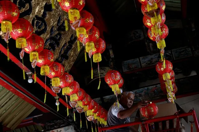 A worker prepares red lanterns to be hung inside the Tay Kak Sie temple ahead of Lunar New Year in Semarang, Central Java province, Indonesia, on February 8, 2024. (Photo by Willy Kurniawan/Reuters)