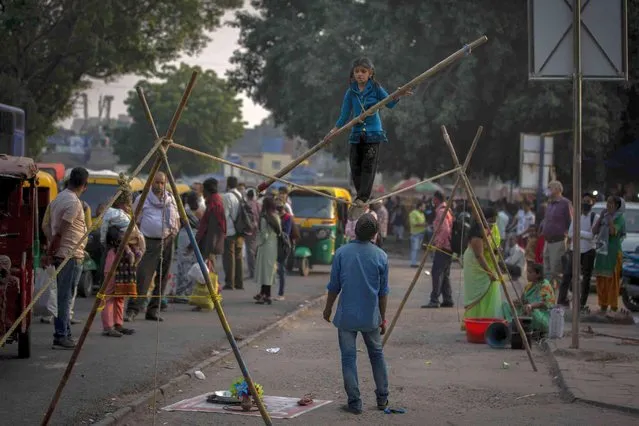 An Indian child street performer walks a tightrope in New Delhi, India, Tuesday, November 2, 2021. (Photo by Altaf Qadri/AP Photo)