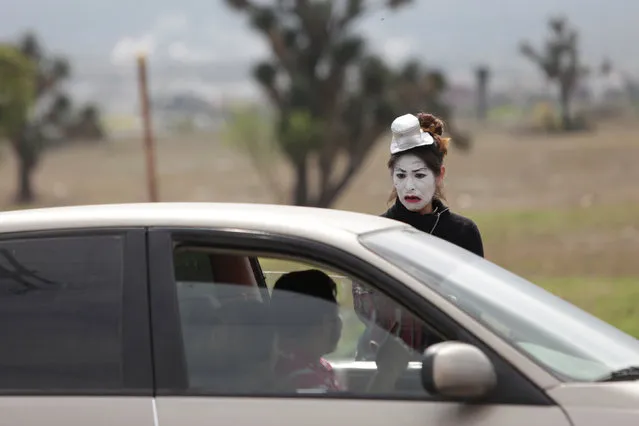 A mime artist gestures to a driver that refused to wear the seatbelt at a traffic light as part of a government programme to raise awareness among motorists and pedestrians to respect transit rules, in the municipality of Garcia, on the outskirts of Monterrey, Mexico February 14, 2017. (Photo by Daniel Becerril/Reuters)