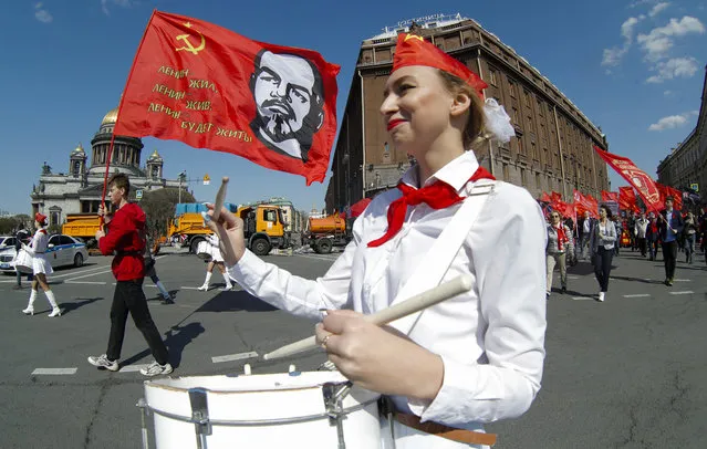 Communist party supporters march with a flag depicting Soviet Union founder Lenin during a May Day rally in St.Petersburg, Russia, Wednesday, May 1, 2019. (Photo by Dmitri Lovetsky/AP Photo)