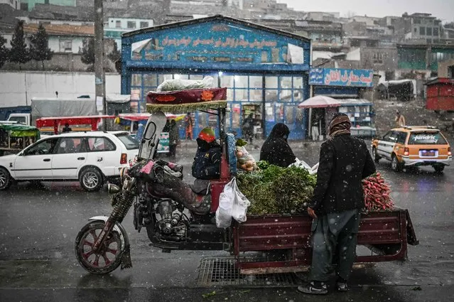 A vendor sells vegetables along a road during the first snow in Kabul on December 15, 2021. (Photo by Mohd Rasfan/AFP Photo)