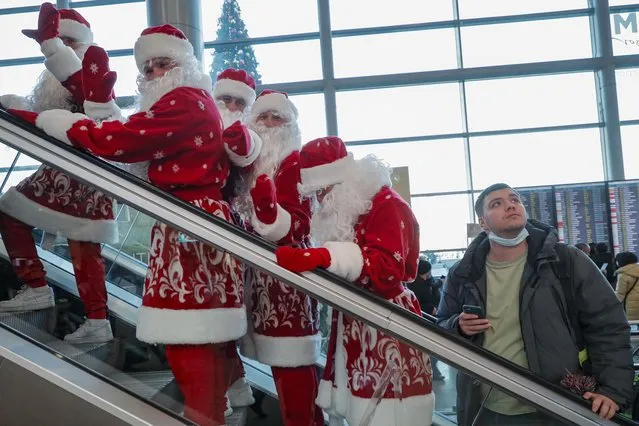Actors dressed as Father Frost use an escalator after performing in the building of the Domodedovo airport named after Mikhail Lomonosov in Moscow, Russia, 27 December 2021. Russians are preparing to celebrate New Year's Eve on 31 December and Christmas which is observed on 07 January, according to the Russian Orthodox Julian calendar, 13 days after Christmas on 25 December on the Gregorian calendar. (Photo by Sergei Ilnitsky/EPA/EFE)