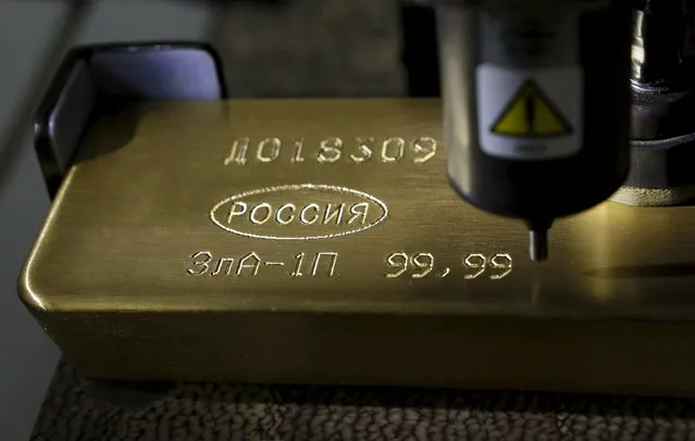 A machine is used to engrave information on an 99.99 percent pure gold ingot at the Krastsvetmet Krasnoyarsk non-ferrous metals plant in the Siberian city of Krasnoyarsk, Russia, June 5, 2015. Krastsvetmet is one of the world's largest players in the precious metals industry. REUTERS/Ilya Naymushin