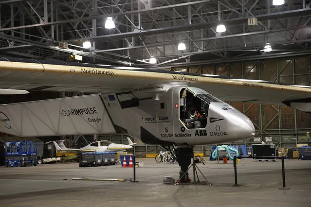 Ground crew prepare for the departure of the Solar Impulse 2 solar plane from the Kalaeloa Airport, Thursday, April 21, 2016, in Kapolei, Hawaii. The Solar Impulse team landed in the islands in July after a record-breaking flight from Japan. (Photo by Marco Garcia/AP Photo)