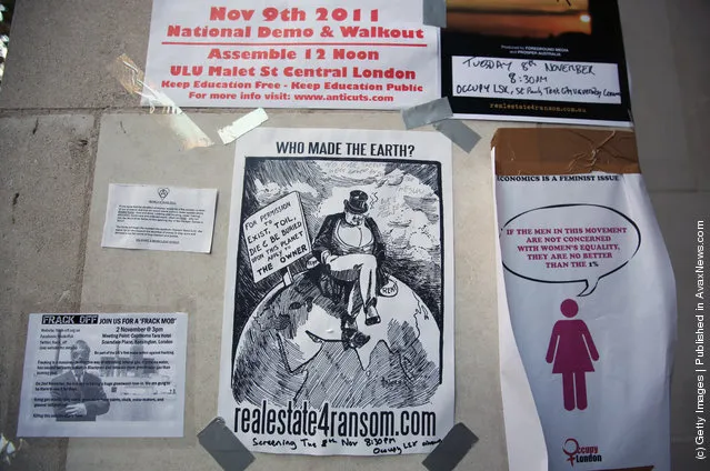 Protest posters are attached to the walls surrounding the Occupy London camp outside St. Paul's Cathedral