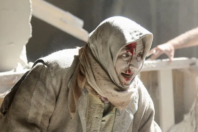 An injured woman reacts at a site hit by airstrikes in the rebel held area of Old Aleppo, Syria, April 28, 2016. (Photo by Abdalrhman Ismail/Reuters)