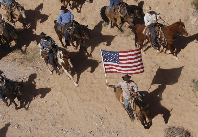 The Bundy family and their supporters fly the American flag as their cattle were released by the Bureau of Land Management back onto public land outside of Bunkerville, Nev. on April 12, 2014. (Photo by Jason Bean/AP Photo/Las Vegas Review-Journal)