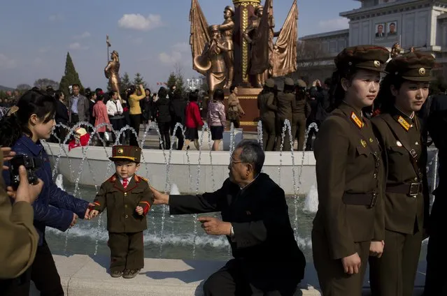 North Korean soldiers and civilians pose for souvenir photos in front of a fountain as they tour the grounds of Kumsusan Palace of the Sun, the mausoleum where the bodies of the late leaders Kim Il Sung and Kim Jong Il lie embalmed, in Pyongyang on Thursday, April 25, 2013. (Photo by David Guttenfelder/AP Photo)