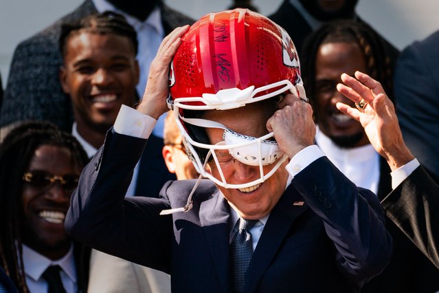 US President Joe Biden puts on a Helmet gifted to him from the Kansas City Chiefs during their celebration White House visit on the South Lawn of the White House on Friday, May 31, 2024. (Photo by Demetrius Freeman/The Washington Post)