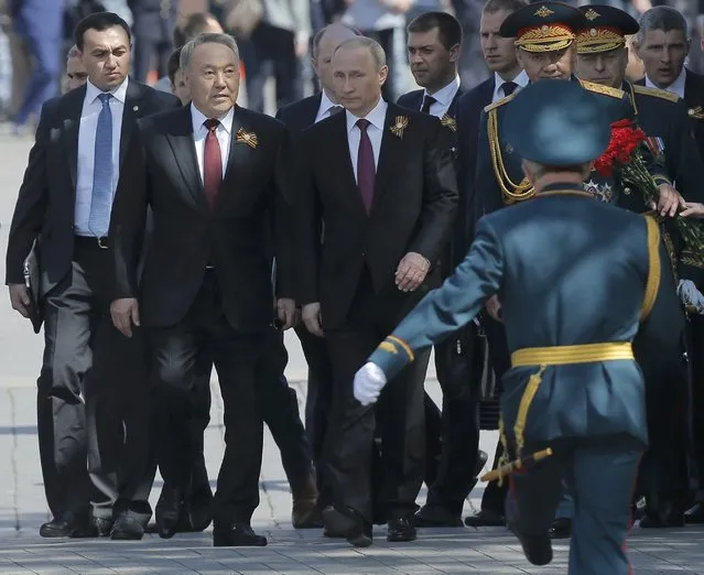 Russian President Vladimir Putin (C), Kazakh President Nursultan Nazarbayev (2nd L) and Russian Defence Minister Sergei Shoigu (2nd R) attend a wreath-laying ceremony to mark the 71st anniversary of the victory over Nazi Germany in World War Two, at the Tomb of the Unknown Soldier by the Kremlin walls in Moscow, Russia, May 9, 2016. (Photo by Maxim Shemetov/Reuters)