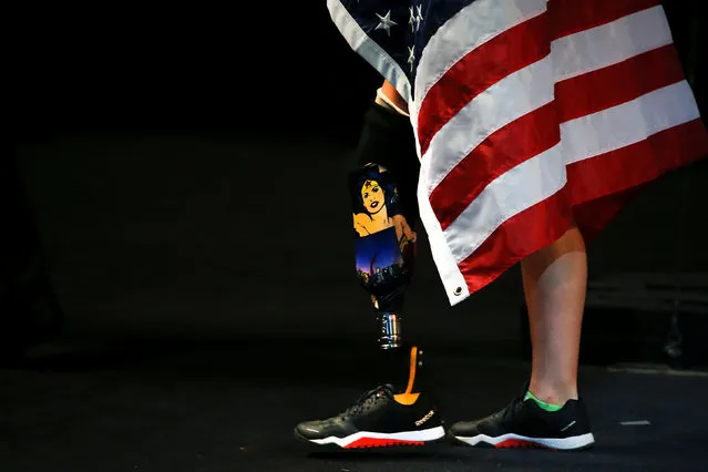 A wounded warrior with an image of Wonder Woman on her prosthetic leg walks off the stage during the medal presentation ceremonies for the indoor rowing during the Invictus Games in Orlando, Florida, U.S., May 9, 2016. (Photo by Carlo Allegri/Reuters)
