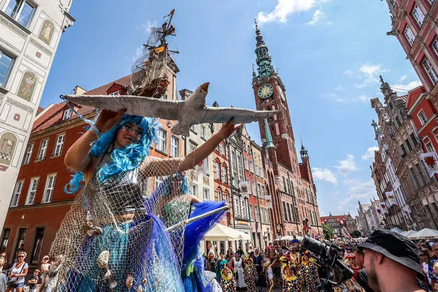 People in costume perform during St. Dominic's Fair in Gdansk, northern Poland, 24 July 2021. Around 650 exhibitors from seven countries took part in the event, during which COVID-19 vaccinations were offered at an outdoor vaccination point. (Photo by Jan Dzban/EPA/EFE)
