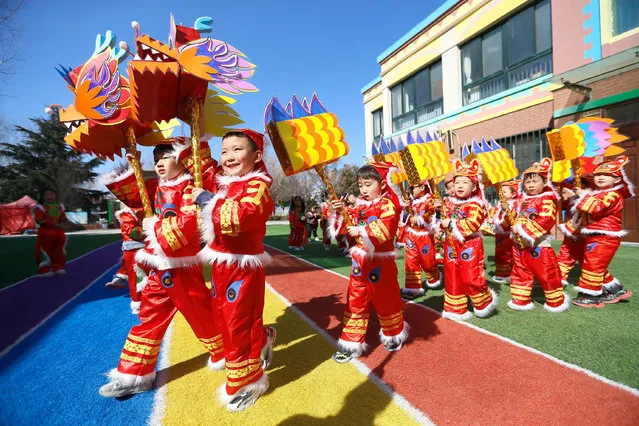 Children perform dragon dance to greet the Longtaitou Day at a kindergarten in Jimo District, Qingdao, east China's Shandong Province, March 3, 2022. Literally meaning “dragon raises head”, the day of Longtaitou, the second day of the second lunar month, falls on Friday this year. Various activities were held to greet the day. (Photo by Xinhua News Agency/Rex Features/Shutterstock)