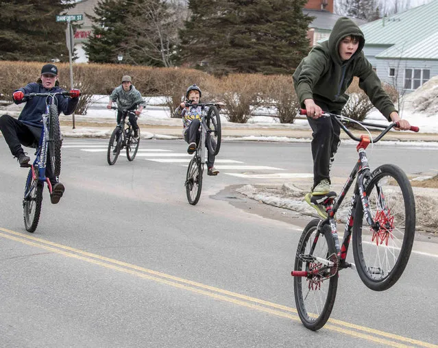 Conner Elsman, right and his friends ride down Beal Street in Norway, Maine, on Wednesday, March 9, 2022. From left to right are Ryan Preston, Anthony Kubicek, Wyatt Brown and Elsman. (Photo by Russ Dillingham/Sun Journal via AP Photo)