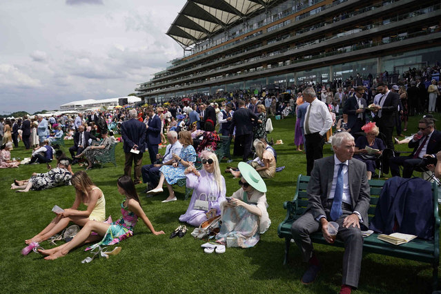 Racegoers relax as they watch the first race on the first day of the Royal Ascot horse race meeting at Ascot, England, Tuesday, June 18, 2024. (Photo by Alberto Pezzali/AP Photo)