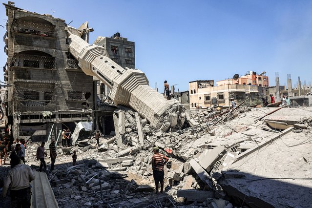 People search the rubble of destroyed buildings near the collapsed minaret of a mosque following Israeli bombardment in Nuseirat in the central Gaza Strip on July 17, 2024 amid the ongoing conflict in the Palestinian territory between Israel and Hamas. (Photo by Eyad Baba/AFP Photo)