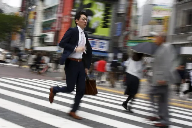 People cross a junction in a shopping district in Tokyo, Japan, April 27, 2016. (Photo by Thomas Peter/Reuters)