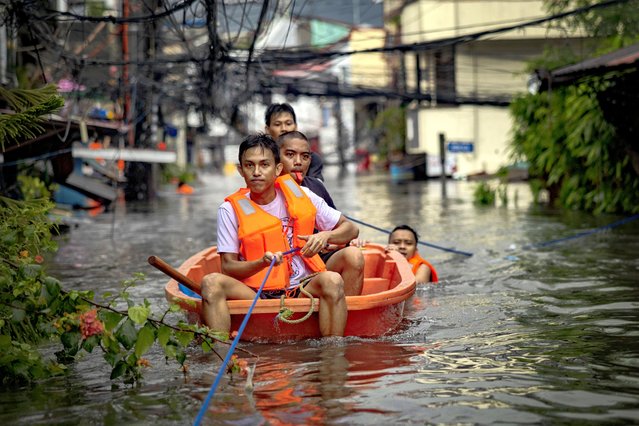 Rescuers ride a boat to reach residents trapped by flooding caused by Typhoon Gaemi and monsoon rains on July 24, 2024 in Quezon city, Metro Manila, Philippines. Monsoon rains, intensified by Typhoon Gaemi, have caused flooding and landslides throughout the Philippines, resulting in at least eight deaths and displacing over 600,000 people. The typhoon, located east of Taiwan Wednesday with up to 162 kph winds, did not make landfall in the Philippines but enhanced monsoon rains. In the region around the capital Manila, government work and schools were suspended due to severe overnight flooding. (Photo by Ezra Acayan/Getty Images)