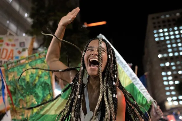 A reveller of a street party known as blocos, dances during a protest against restrictions by city officials in Rio de Janeiro, Brazil, Wednesday, April 13, 2022. City Hall has banned the street parties during Carnival celebrations, which were delayed by almost two months due to the pandemic. (Photo by Silvia Izquierdo/AP Photo)