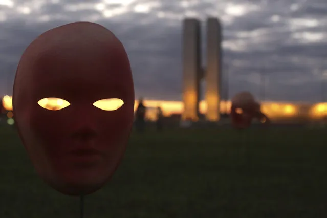 Masks representing corrupt politicians are placed by protesters on the lawn outside the National Congress building, in Brasilia, Brazil, Tuesday, May 23, 2017. Brazil's Supreme Court has opened investigations into President Michel Temer for allegedly obstructing justice, passive corruption and being a member of a criminal organization. The move follows release of an audiotape that appears to show him endorsing the payment of hush money to an imprisoned former ally in exchange for silence. (Photo by Eraldo Peres/AP Photo)