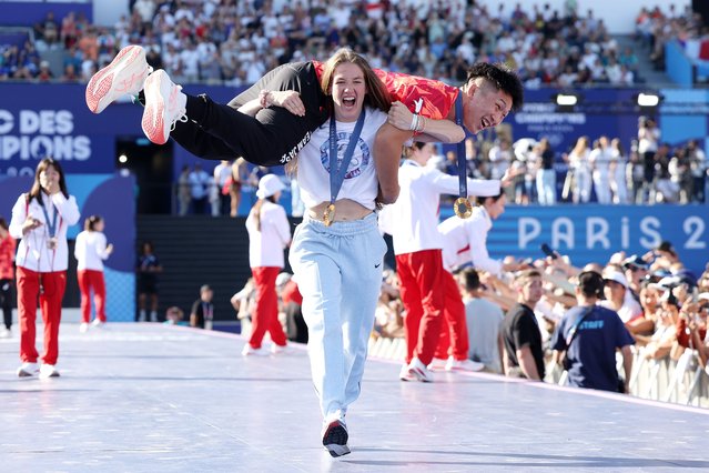 Women's Freestyle 50kg wrestling gold medalist Sarah Hildebrandt of Team United States carries Men's Greco-Roman 77kg wrestling gold medalist Nao Kusaka of Team Japan on stage on day thirteen of the Olympic Games Paris 2024 at Champions Park on August 08, 2024 in Paris, France. (Photo by Luke Hales/Getty Images)