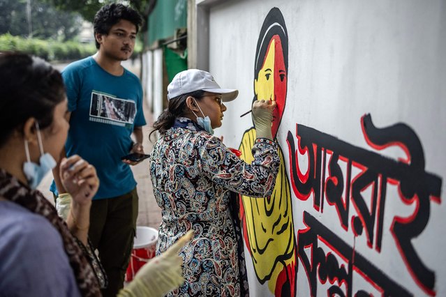 A student paints a wall with revolutionary motifs to cover old murals related to the regime of Sheikh Hasina and the Awami League party in the streets of Dhaka on August 12, 2024. Gone are the slogans of last week, demanding the “killer dictator” quit: if you ask Bangladesh's youth whether they're hopeful about the future, the writing is on the wall. Students who led the weeks of protests that toppled autocratic premier Sheikh Hasina are back on the streets to give the capital Dhaka a makeover. (Photo by Luis Tato/AFP Photo)