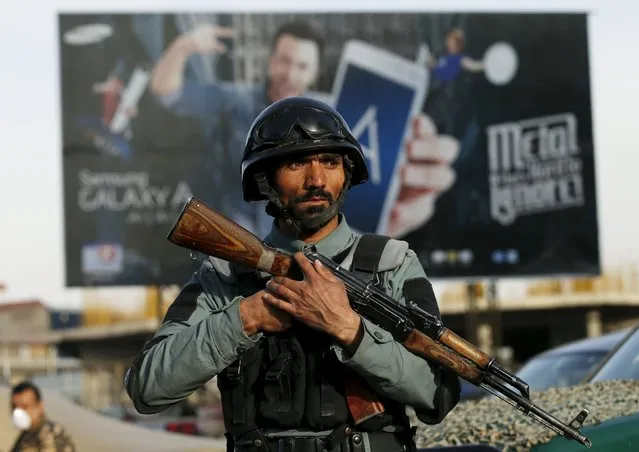 An Afghan policeman stands guard at the site of a blast in Kabul, Afghanistan May 19, 2015. A bomb exploded in the parking lot of Afghanistan's Ministry of Justice on Tuesday, killing at least five people and wounding dozens as civil servants were leaving work for the day, officials said. (Photo by Mohammad Ismail/Reuters)