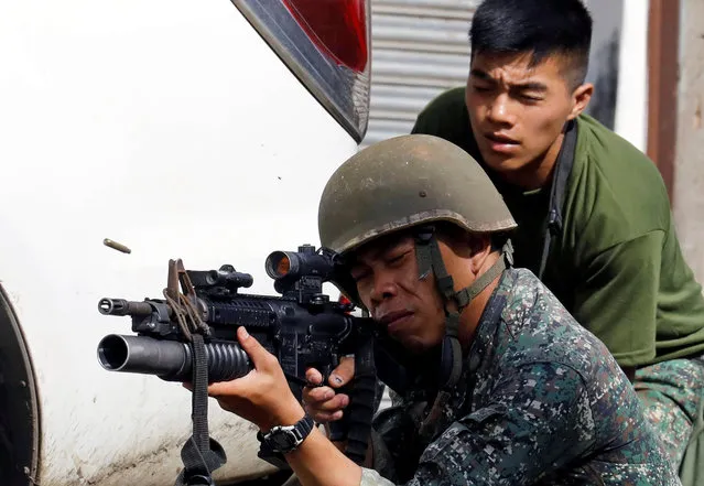 A Philippine Marine fires his weapon towards the stronghold of Maute group in Marawi City, southern Philippines May 30, 2017. (Photo by Erik De Castro/Reuters)