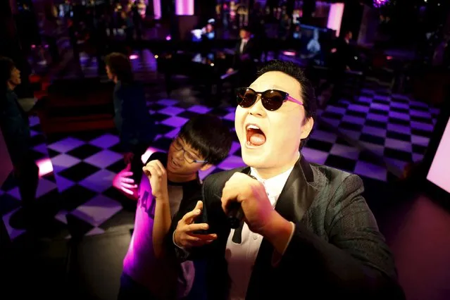 A boy poses for photographs next to the wax figure of South Korean singer Psy at Grevin Wax Museum in central Seoul, South Korea, July 30, 2015. French wax museum Musee Grevin has opened its first Asian branch in central Seoul with about 80 wax figures including those from hallyu (the Korean pop culture wave) displayed, according to local media. (Photo by Kim Hong-Ji/Reuters)
