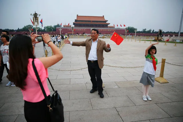 A girl salutes as others take pictures of themselves during a flag-raising ceremony at the Tiananmen Square in Beijing, China June 4, 2016. (Photo by Damir Sagolj/Reuters)