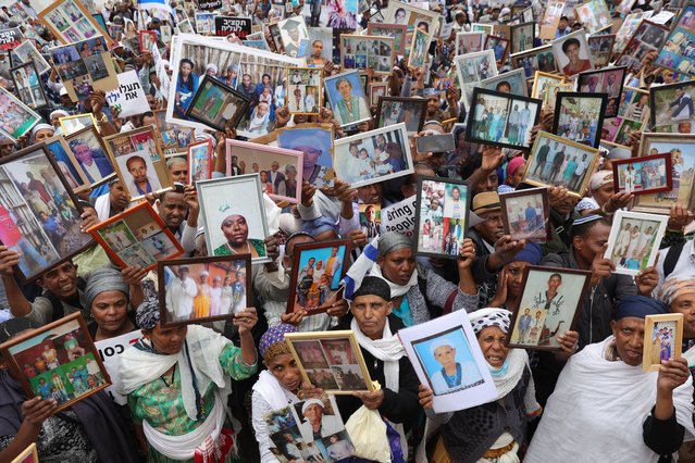 Ethiopian Jews display photographs of relatives still in Ethiopia, during a march protest toward the Israeli Prime Minister office in Jerusalem 28 May 2023. The protesters are calling on the government to allow Ethiopian Jews still in Ethiopia, called Falash Mura, to join their relatives in Israel. (Photo by Abir Sultan/EPA)