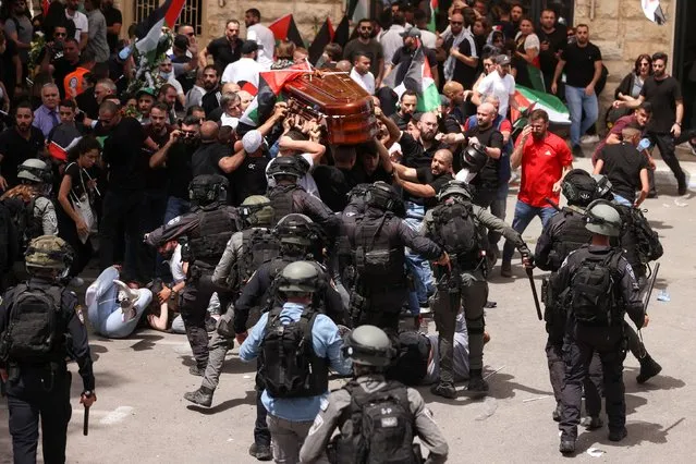 Family and friends carry the coffin of Al Jazeera reporter Shireen Abu Akleh, who was killed during an Israeli raid in Jenin in the occupied West Bank, as clashes erupted with Israeli security forces, during her funeral in Jerusalem, May 13, 2022. (Photo by Ammar Awad/Reuters)