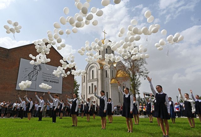 Children release white balloons outside the former school, which came under an attack by Islamist militants in 2004 and is currently a centre of patriotic education and terrorism prevention, during a commemoration ceremony marking the 20th anniversary of the deadly school siege in Beslan in the region of North Ossetia–Alania, Russia on September 3, 2024. (Photo by Sergey Pivovarov/Reuters)