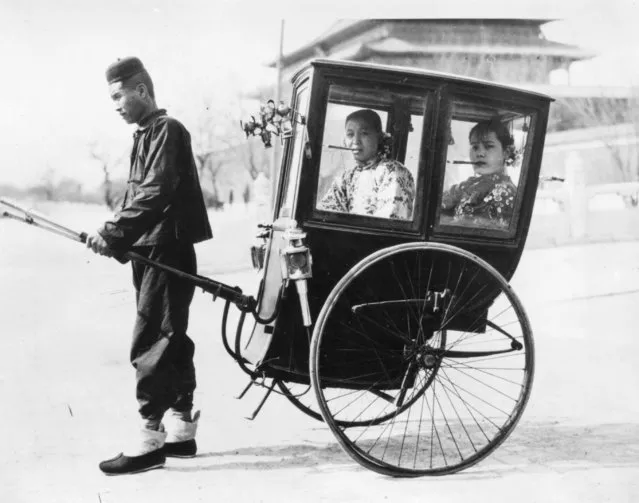 Two women prominant in Chinese film circles; Mrs Loo, in front, and Mrs Newsreel Wong, back, take a man-powered cab in Peking, 19th May 1926. (Photo by Topical Press Agency/Getty Images)