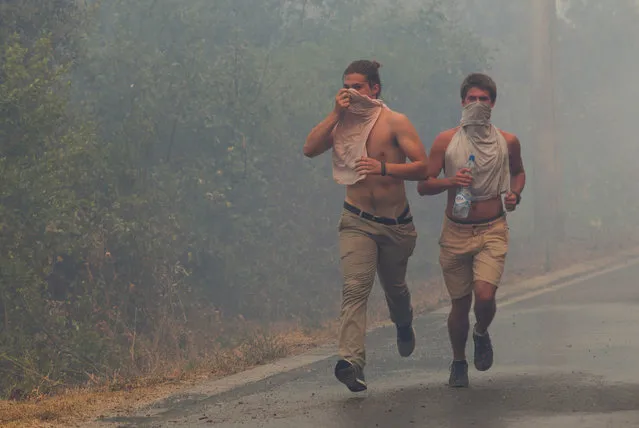 Tourists run through smoke during a forest fire at Lustica peninsula near Tivat, Montenegro, July 17, 2017. (Photo by Stevo Vasiljevic/Reuters)