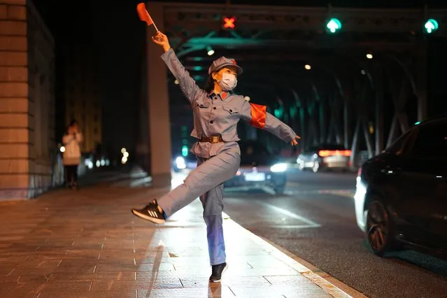 A woman wearing a Red Army uniform dances at the Bund at midnight on June 1, 2022 in Shanghai, China. Shanghai will fully restore the normal order of production and living starting from Wednesday. (Photo by Zheng Xianzhang/VCG via Getty Images)