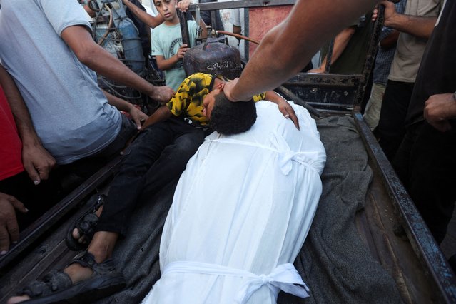 A boy mourns near the body of his father and other Palestinians, who were killed in an Israeli strike, amid the Israel-Hamas conflict, at Al-Aqsa Martyrs Hospital in Deir Al-Balah in the central Gaza Strip on October 9, 2024. (Photo by Ramadan Abed/Reuters)