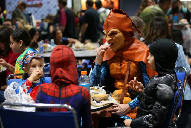 Andre Rhoden, dressed as Marvel supervillain Hobgoblin, takes children to lunch on the floor at Comic-Con in San Diego, US on July 22, 2017. (Photo by Mike Blake/Reuters)