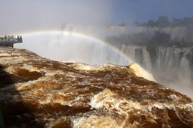 Tourists view the Iguazu Falls from an observation platform at the Iguazu National Park near the southern Brazilian city of Foz do Iguacu June 16, 2014. Forming a border between Argentina and Brazil, the Iguazu Falls, South America's largest falls, attract more than 1 million visitors a year. (Photo by Jorge Adorno/Reuters)