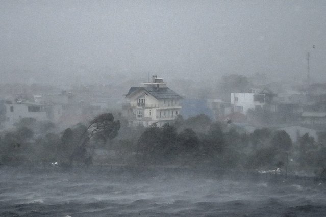 Water is whipped up by high winds onto the shore of Phuong Luu lake as Super Typhoon Yagi hits Hai Phong on September 7, 2024. Super Typhoon Yagi uprooted thousands of trees and swept ships and boats out to sea as it made landfall in northern Vietnam on September 7, state media said. (Photo by Nhac Nguyen/AFP Photo)