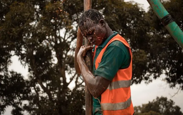 A former child soldier works on the construction of a borehole in Bangui on November 17, 2019. To help the integration of child soldiers from armed groups, several NGOs have set up vocational training for them. In total, more than 13,000 children have been removed from armed groups in the Central African Republic since 2014, according to UNICEF. (Photo by Florent Vergnes/AFP Photo)