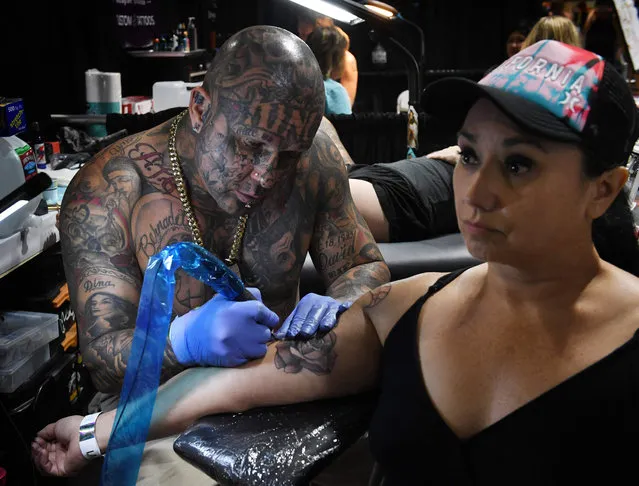 Tattoo artist Blaise Moreno from King Blaise Studio, works on a tattoo for Veronica Angel at the LA Tattoo Convention in Long Beach, California, on August 19, 2017. (Photo by Mark Ralston/AFP Photo)