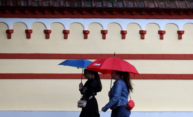 Women walk with umbrellas during a rainy autumn day in Sofia, Bulgaria, 29 September 2024. A yellow code has been announced for significant precipitation in Western Bulgaria and strong winds in Southern and Eastern Bulgaria. (Photo by Vassil Donev/EPA/EFE)