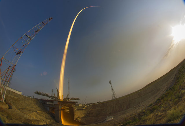 In this photo taken with a fisheye lens and with long time exposure, the Soyuz-FG rocket booster with Soyuz MS space ship carrying a new crew to the International Space Station, ISS, blasts off at the Russian leased Baikonur cosmodrome, Kazakhstan, Thursday, July 7, 2016. (Photo by Dmitri Lovetsky/AP Photo)