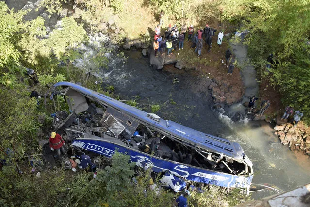 A view of the wreckage of a bus that plunged into Nithi bridge on Sunday, in Tharaka Nithi county Meru, Kenya, Monday, July 25, 2022. Police in Kenya say at least 21 people have died after a bus fell off a bridge and plunged into a river along the highway from the capital, Nairobi, to the central town of Meru. One senior policeman said the bus, traveling from Meru, “must have developed brake failure because it was at a very high speed” when the crash occurred. (Photo by Dennis Dibondo/AP Photo)