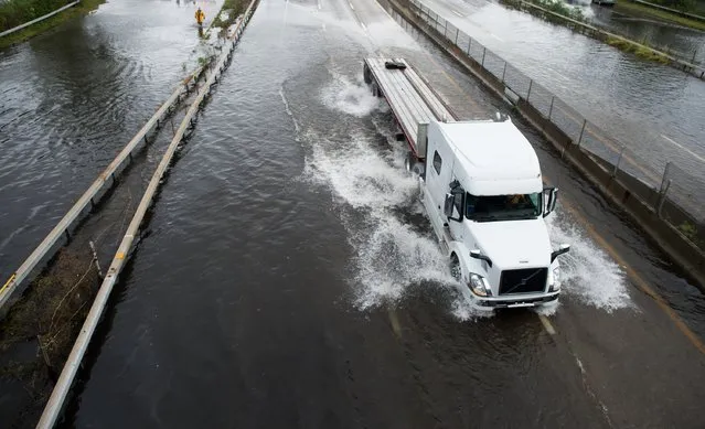 A trailer truck traverses a flooded street at Sunrise Highway following heavy rains and flash flooding August 13, 2014 in Bayshore, New York. The south shore of Long Island along with the tri-state region saw record setting rain that caused roads to flood entrapping some motorists. (Photo by Andrew Theodorakis/Getty Images)