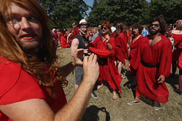 Participants dressed as singer Kate Bush from her 1978 video to her song “Wuthering Heights” snap phots of each other after attempting to create a new world's record for the most people dancing in costume to the song at once at Tempelhofer Feld park on July 16, 2016 in Berlin, Germany. (Photo by Sean Gallup/Getty Images)