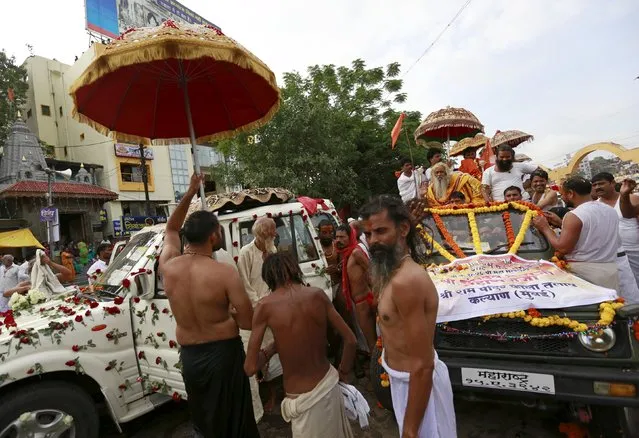 Sadhus or Hindu holy men arrive to take a dip in the Godavari river during the first Shahi Snan (grand bath) at Kumbh Mela, or Pitcher Festival in Nashik, India, August 29, 2015. (Photo by Danish Siddiqui/Reuters)