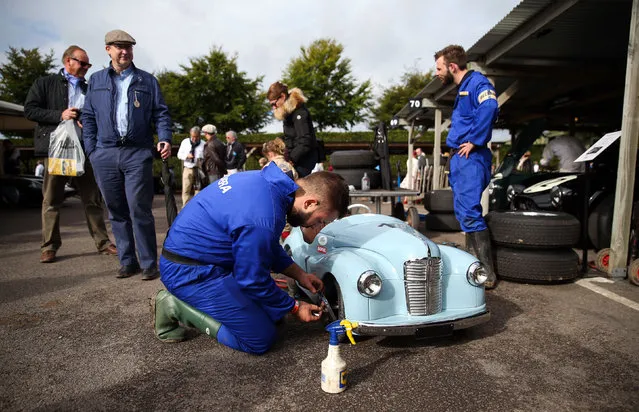 A mechanic works on a pedal car used in the Settrington Cup during the Goodwood Revival festival on September 9, 2017 in Chichester, England. (Photo by Andrew Matthews/PA Wire)